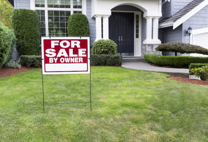 House for sale sign on lawn of tide home